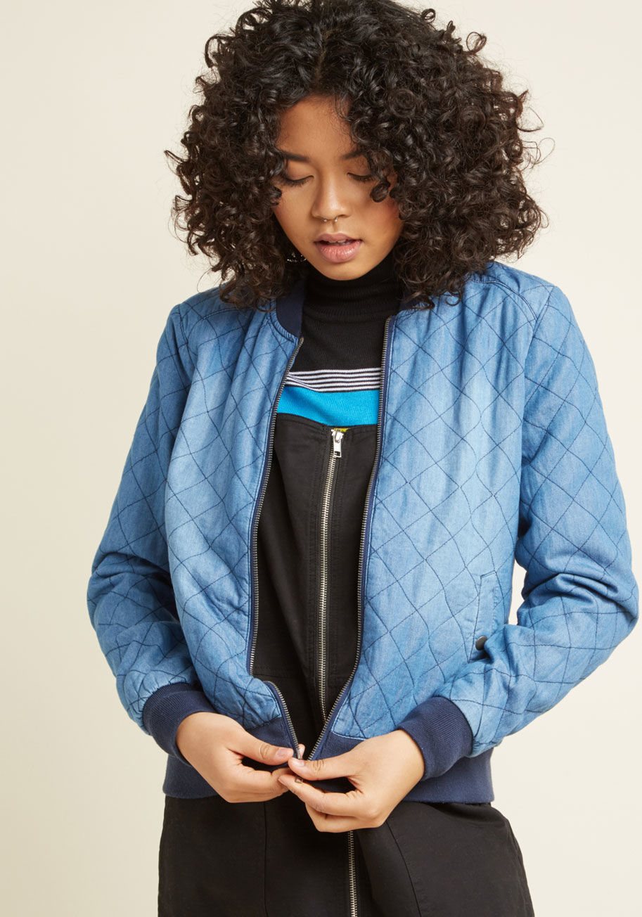 250413-BD - A quick run to the coffee shop becomes quite the fashionable foray when this chambray bomber jacket is involved! Quilted from its classic ribbed neckline down to its matching cuffs and hem, pocketed to perfection, and subtly splashed with a lighter wash f