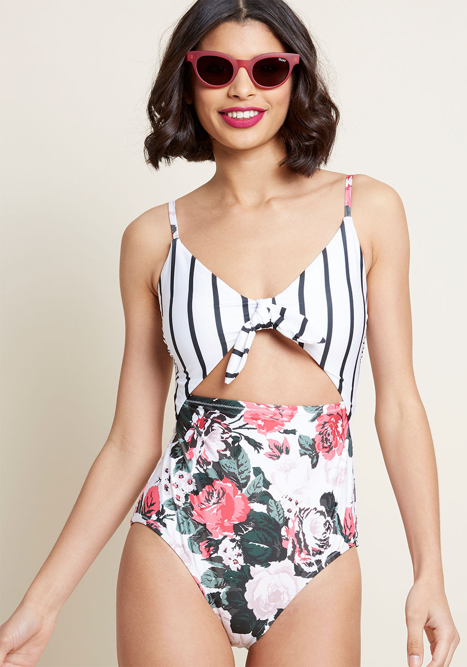 MC0836-5988 - Did someone say sunshine? The promise of warm rays means you've gotta show off this sultry swimsuit! From High Dive by ModCloth, this one piece touts sleek straps, a black-striped 'n' knotted bust, a daring midriff cutout, and floral-printed bottoms, crea