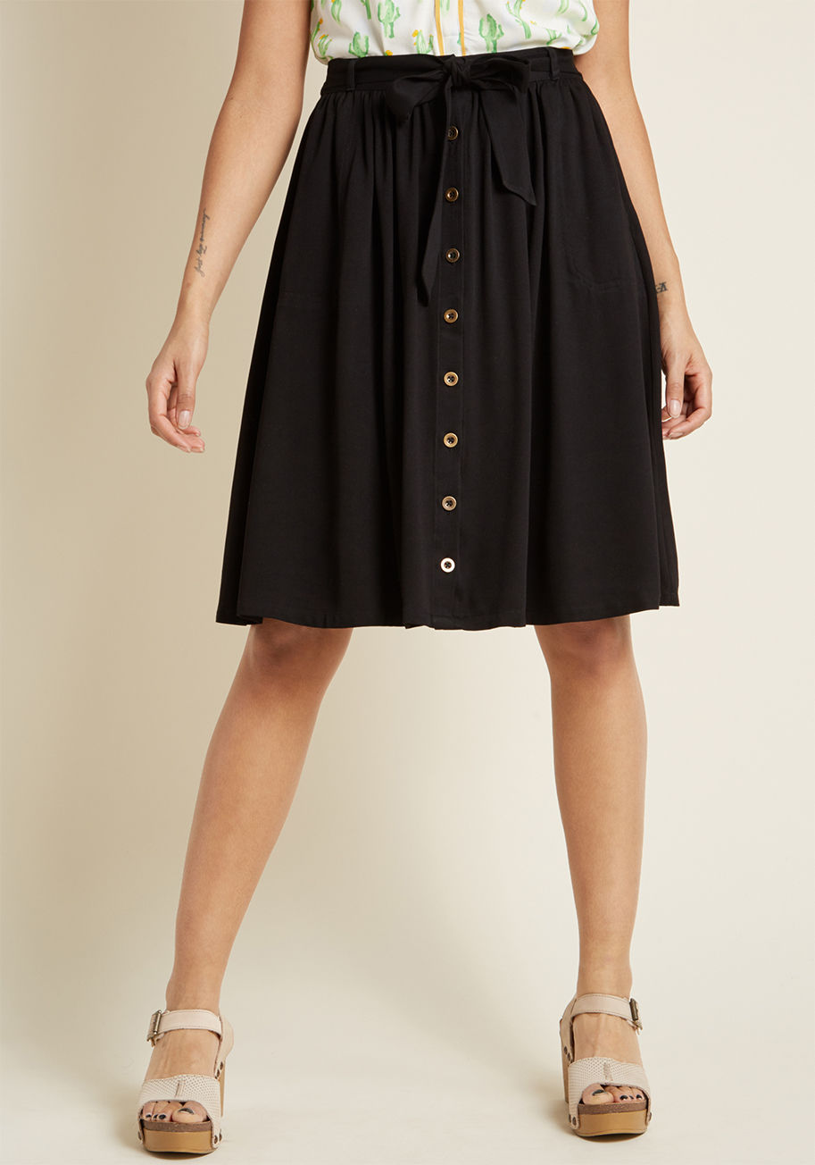 MCB1372 - The perfect pairing for your imaginative outfitting ideas, this black A-line skirt is one you'll wear to wow on the reg! Rocking a sash topping its elasticized-back waist, bronze front buttons, and side pockets, this ModCloth namesake label separate turns
