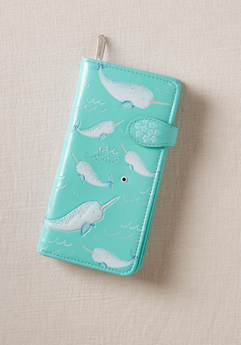 W009802 - Whether or not this faux-leather wallet is overflowing with cash, its quirk and cuteness are always abundant, and that's a sure win! This textured accessory is patterned with happy narwhals swimming through occasionally embroidered waves, and equipped wit