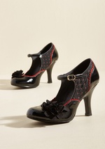 Demonstrate your wisdom for all things flowery by buckling into these black pumps from Ruby Shoo! Touches of gloss highlight the counters and toes of this red-and-white dotted pair, while crimson scallops frame each end beautifully. Topped with two triod  by Ashley
