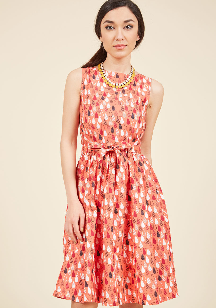  - A flirty frock for your upcoming cruise, this coral dress is as refreshing as a sea breeze! Magenta, white, and navy raindrops, filled with stripes and dots, pattern this bow-tied A-line, completing a new fashion favorite that&rsquo;s &lsquo;shore&rsquo; 