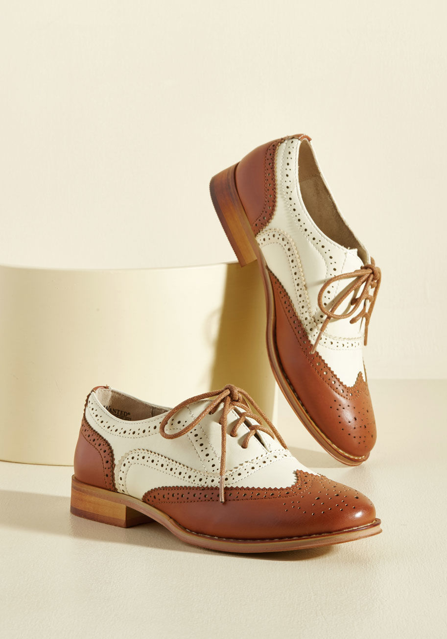  - And now for your feature presentation - these caramel wingtips! Totally classic, these retro, faux-leather kicks boast ivory uppers, a glossy sole, perforated details, and tons of personality.