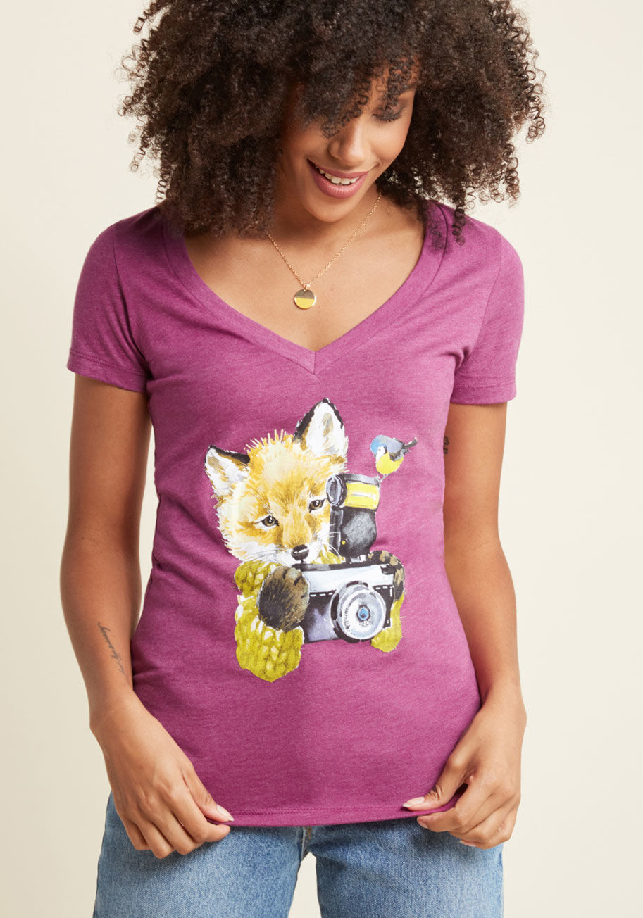  - As the sweater-clad fox screen printed on this tee adjusts his camera settings, you focus your attention on the bird perched atop its flash! In a wonderful watercolor display, this scene is featured aneath the V-neckline of this magenta ModCloth exclusive