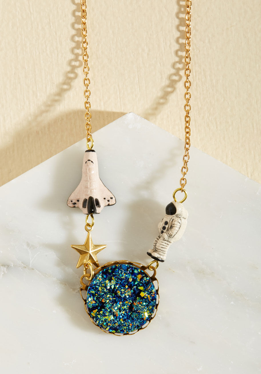 Be warned - wearing this gold necklace by Eclectic Eccentricity will inspire a quick trip to the planetarium! The observatory displays galaxies which resemble your accessory&rsquo;s druzy-inspired blue cabochon, while its astronaut and shuttle charms enco by 