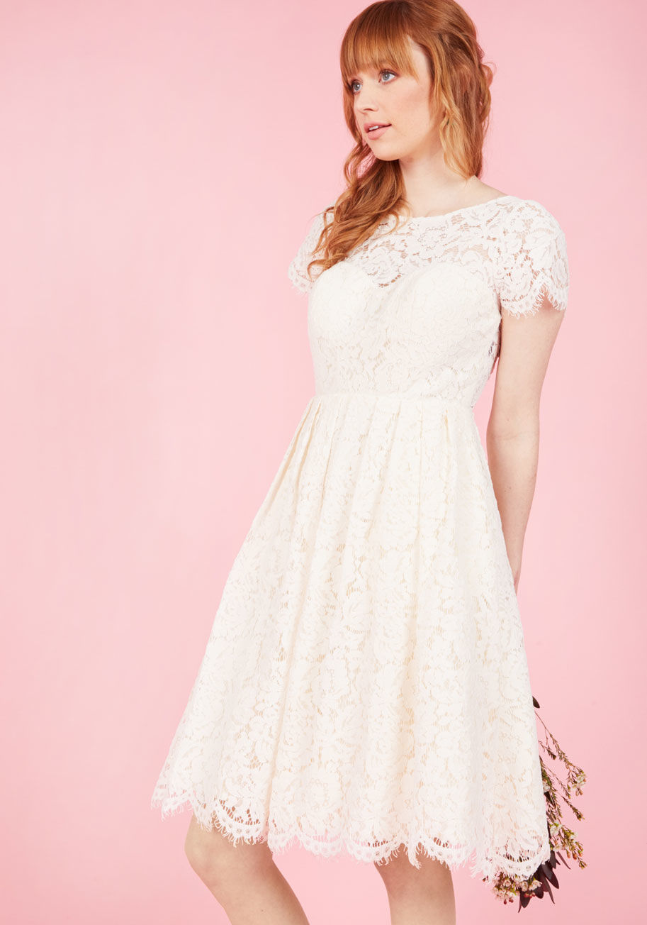  - Before you even debut this ivory midi dress by Jenny Yoo, you'll celebrate a moment of fab flattery to yourself. Gorgeously glammed up with an illusion neckline, a padded sweetheart neckline opposite an eyelash-fringed open back, and a pretty pleated wais