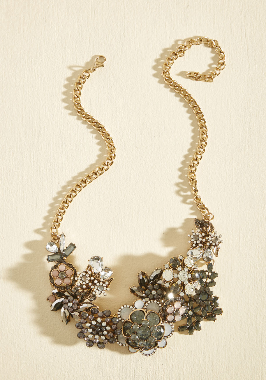 Each time you clasp the golden curb chain of this statement necklace at your nape, you&rsquo;re making a promise to fill the air with flair! Clusters of navy, purple, opalescent, and clear gemstones form a garden of glam flowers, turning heads and inspiri by 