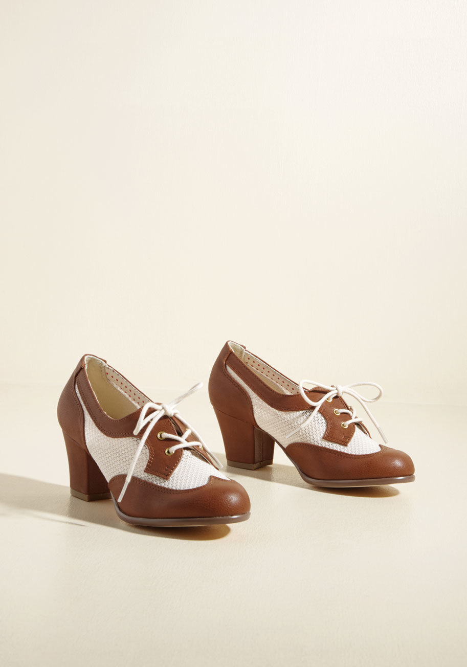  - Embody the gracefulness and grit of bygone times with these brown block heels from B.A.I.T. Footwear! Crafted into a sentimental Oxford silhouette touched with sheer ivory sides, gold grommets, and wing-tipped toes, these faux-leather kicks emit vintage a