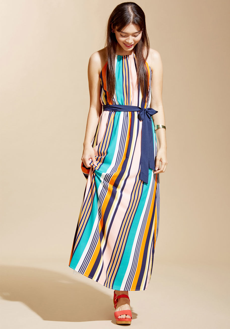  - Even though the last rays of light illuminating your tie-dye maxi dress are fading behind the ocean, the roar of the bonfire will lend itself to keeping your look lit up! Secured behind the neck and around the waist with navy ties, this purple and white f