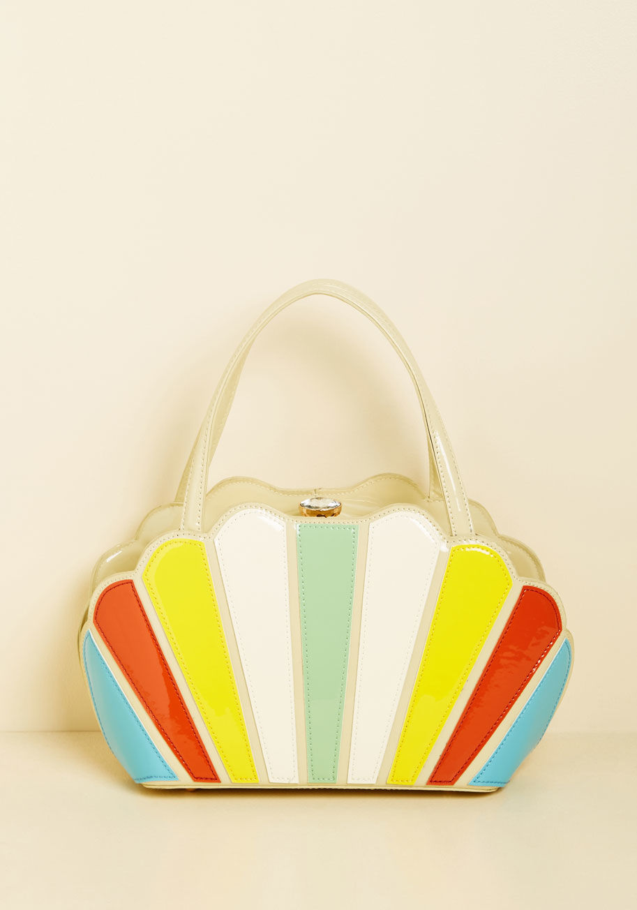  - Glossy, colorblocked, and vintage-inspired - when it comes to this taupe handbag from Banned, consider us sold! Between the scalloped edges of this statement satchel lies a stunning faux-gem closure, which reveals its spacious interior as perfect for stow