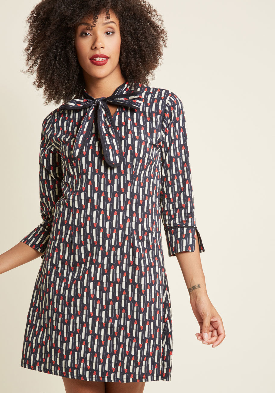  - Kiss days of wardrobe doldrums goodbye! This cotton shift dress infuses your look with quirk and class, courtesy of its tied neckline, cropped sleeves, and adorable print of red lipstick tubes atop a classy navy hue. Talk about a modern and marvelous way 