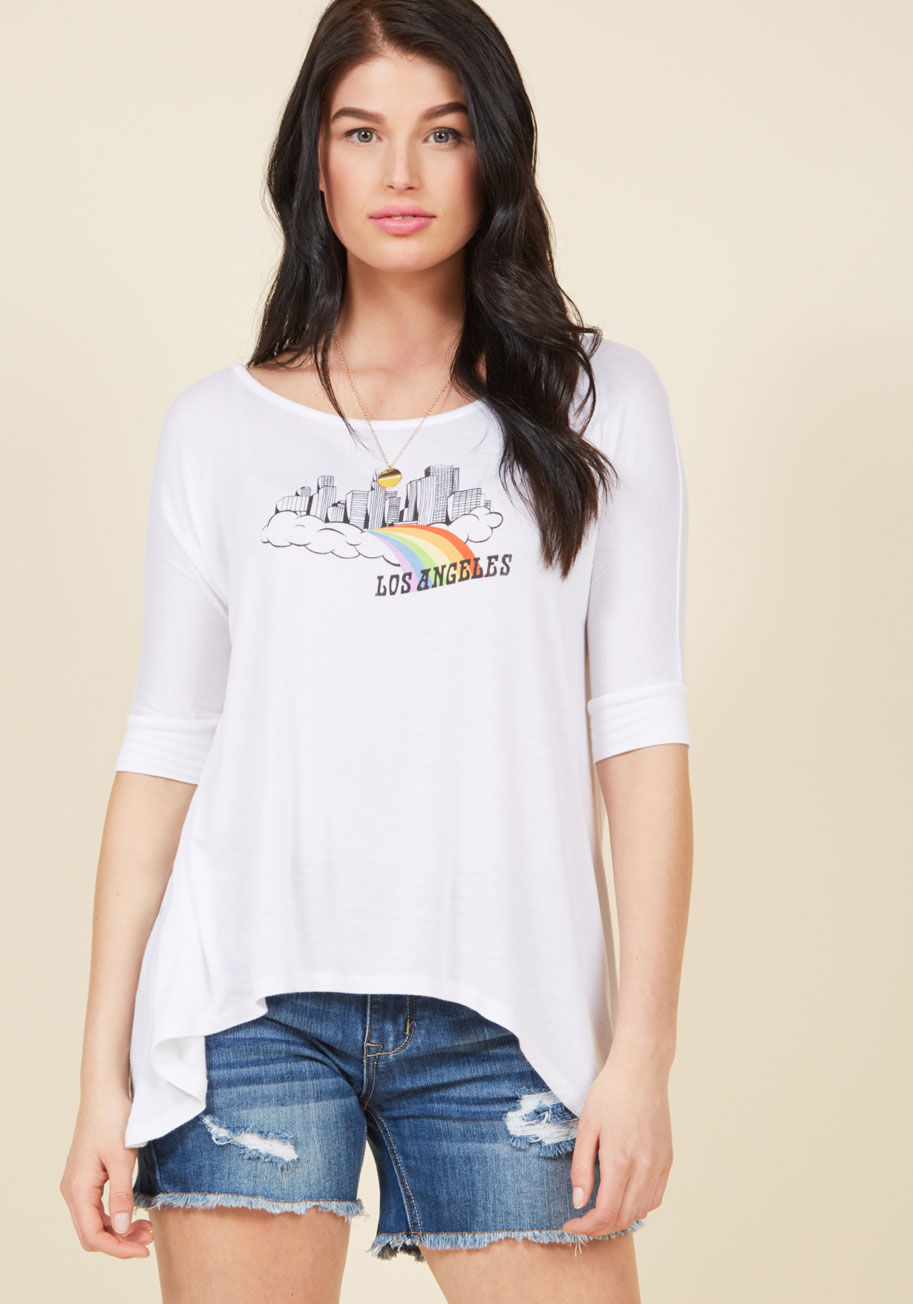  - Let this white T-shirt be the first step on your journey to becoming a more stylish self! Flaunting half sleeves, a shark tail hem, and a screen print of your fave city floating on a cloud, this ModCloth-exclusive top will comfortably accompany you on all