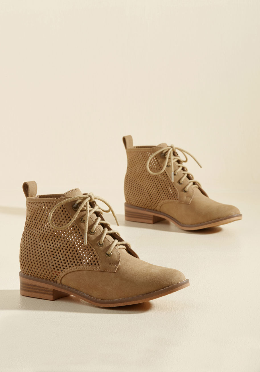  - Other travelers will greet you with compliments when they cross paths with your tan booties! While they ooh and ahh over the perforated shafts and antiqued gold grommets of your faux-leather footwear, you find each destination more welcoming than the last