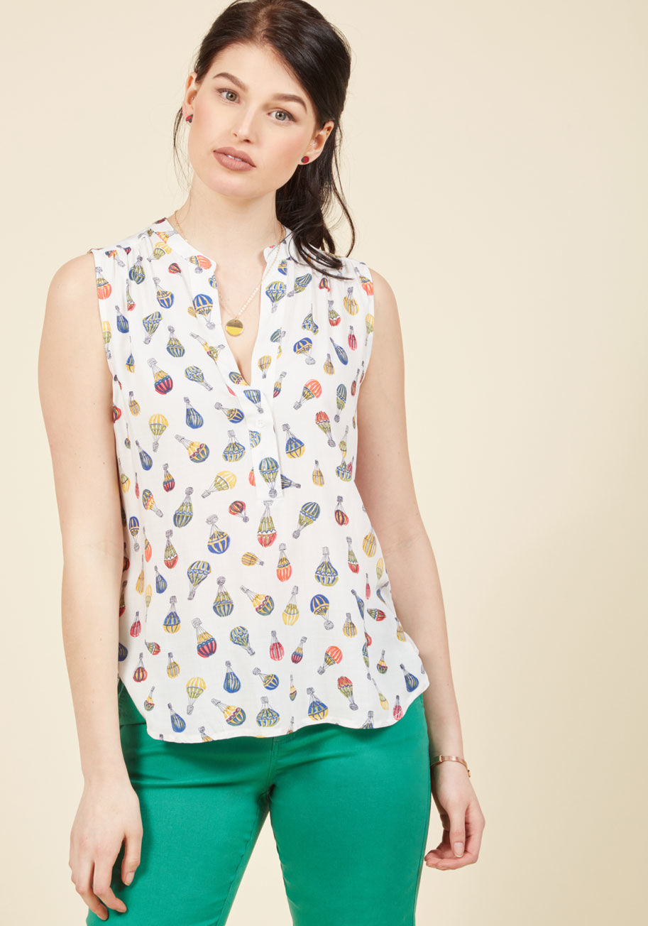  - Take your style up, up, and away into sky-high levels of cuteness with this cloud white blouse! A sleeveless look with subtly gathered shoulders and a rainbow of hot air balloons soaring across its casual silhouette, this quirky tank top is a &lsquo;float