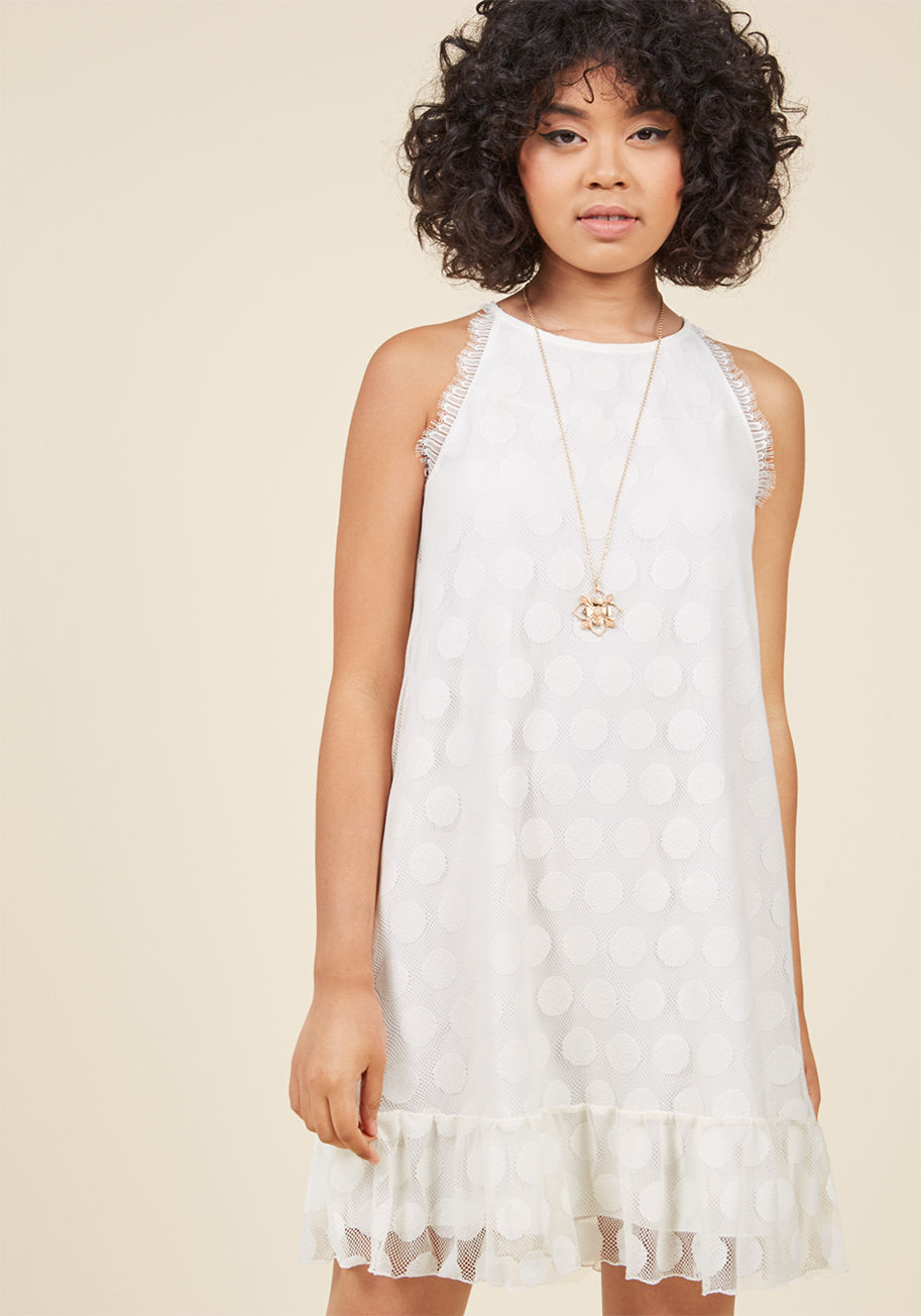  - The ivory hue, sweet high neckline, and feminine hemline ruffle of this shift dress culminate