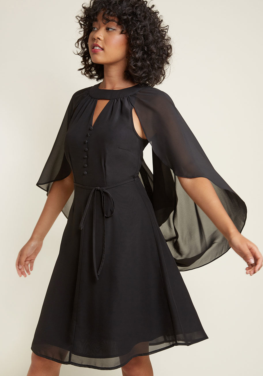  - The neckline cutout and delicate buttons of this black dress from our ModCloth namesake label make this look a delight, but those are only the beginning. This vintage-inspired frock's gorgeous cape - which can be worn draped over the shoulders or tossed b