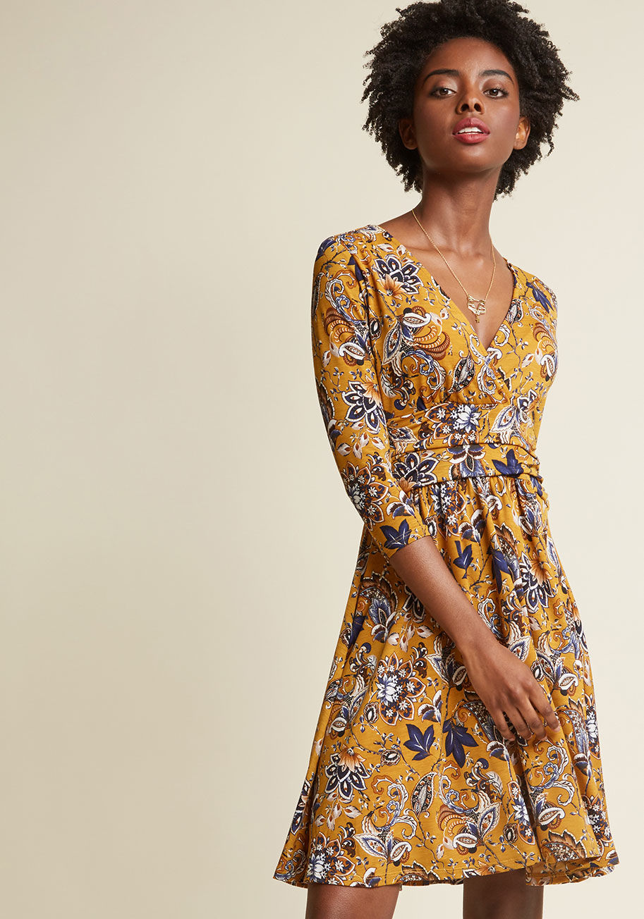  - This mustard dress hands-down must go on every trip with you. Why? Well, its surplice neckline and broad, side-ruched waistband offer an ever-flattering fit, its 3/4-length sleeves and short silhouette combine to coordinate with all sorts of weather forec