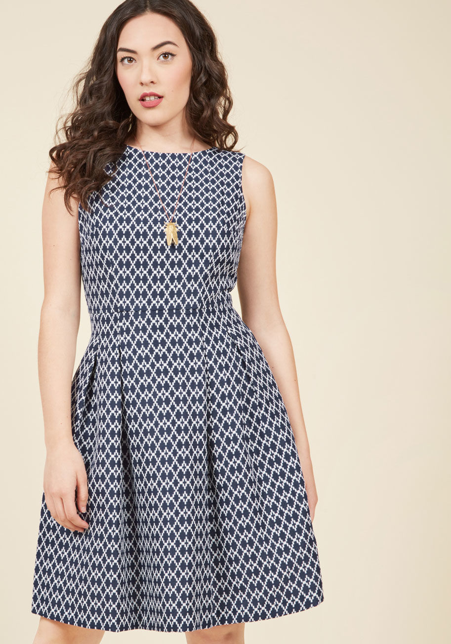  - This navy blue frock's tailored bodice and white, brocade diamond pattern are stylishly sophisticated enough to withstand the pressures of today's presentation. But, at an al fresco outing is when the tasteful V-back and classic skirt pleats of this pocke