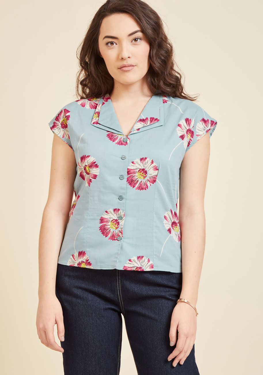  - Those whose impressions of work blouses are limited to stuffy oxfords will have their eyes opened by this dusty blue top! Designed by hard-to-find British brand Emily and Fin, this cotton separate uses vented cap sleeves, a double collar, and fuchsia, lim