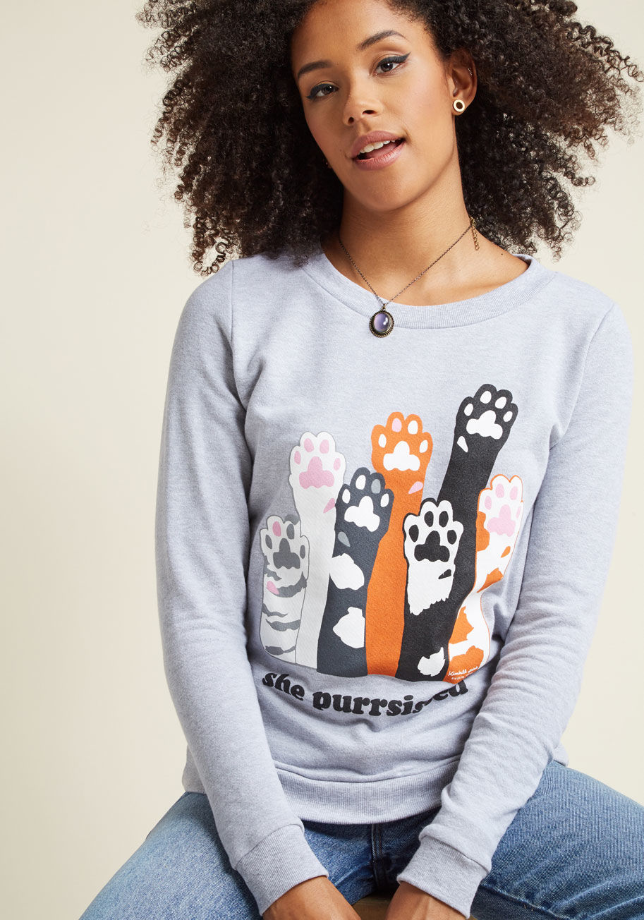  - To survive present-day politics, it certainly helps to be strong and have a sense of humor. This grey pullover both amuses and empowers with a ModCloth-exclusive graphic from Kimball Prints of kitty paws raised