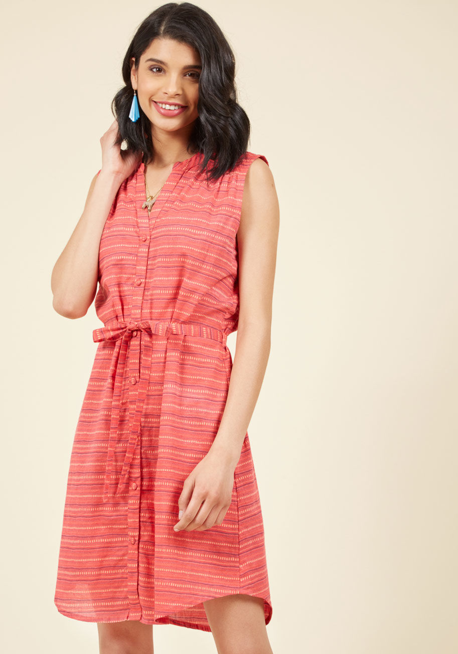  - Tuck this bright coral dress into the driver's seat and welcome the wind to dance along its violet and rose rows of dashes and dots! With a notched neckline, gathered shoulders, and a sash cinching its buttoned length, this cotton dress by Mata Traders ta