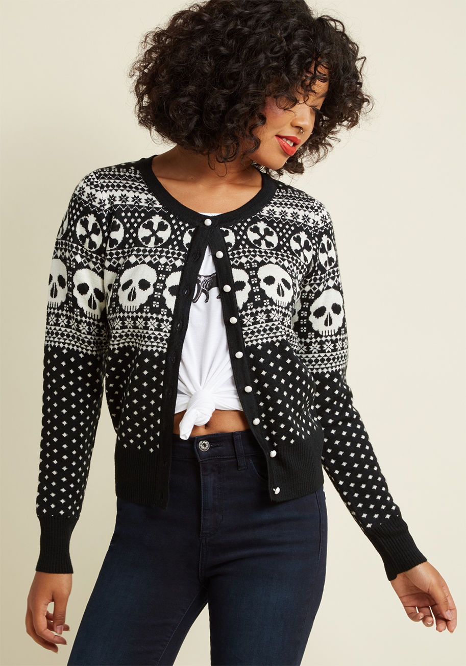  - Upgrade your red-and-green garb for this black cardigan! Made unconventionally cheerful with a print of crossbone ornaments and Fair Isle skulls along with pearly buttons, this macabre sweater puts your edgy seasonal style on the top of everyone&rsquo;s &