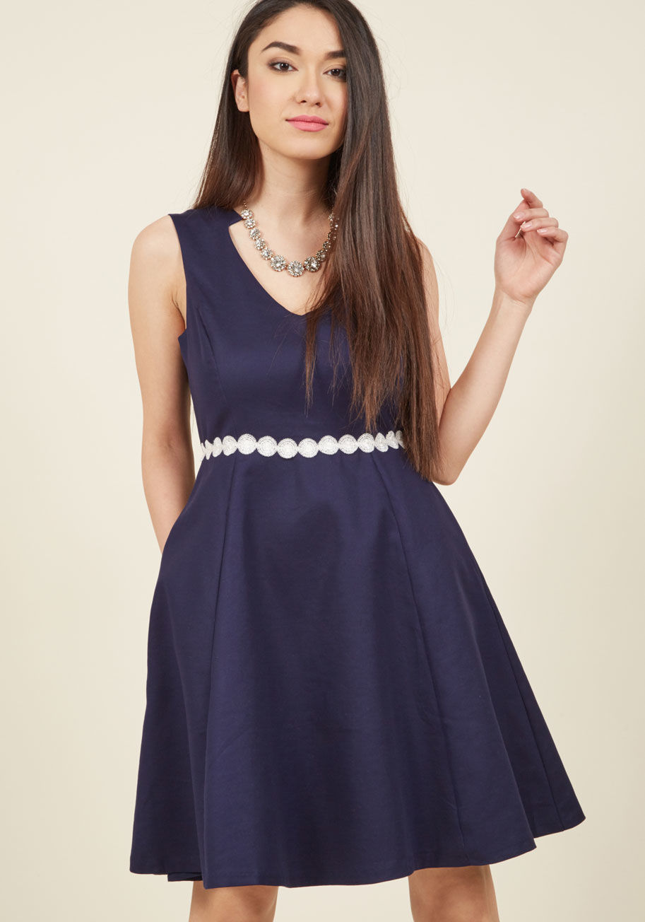  - When determining whether you must have a certain garment, it all comes down to special touches. This navy dress appears couth and classic from a distance, but upon closer inspection, its design reveals a retro neckline, white circle appliques around the w
