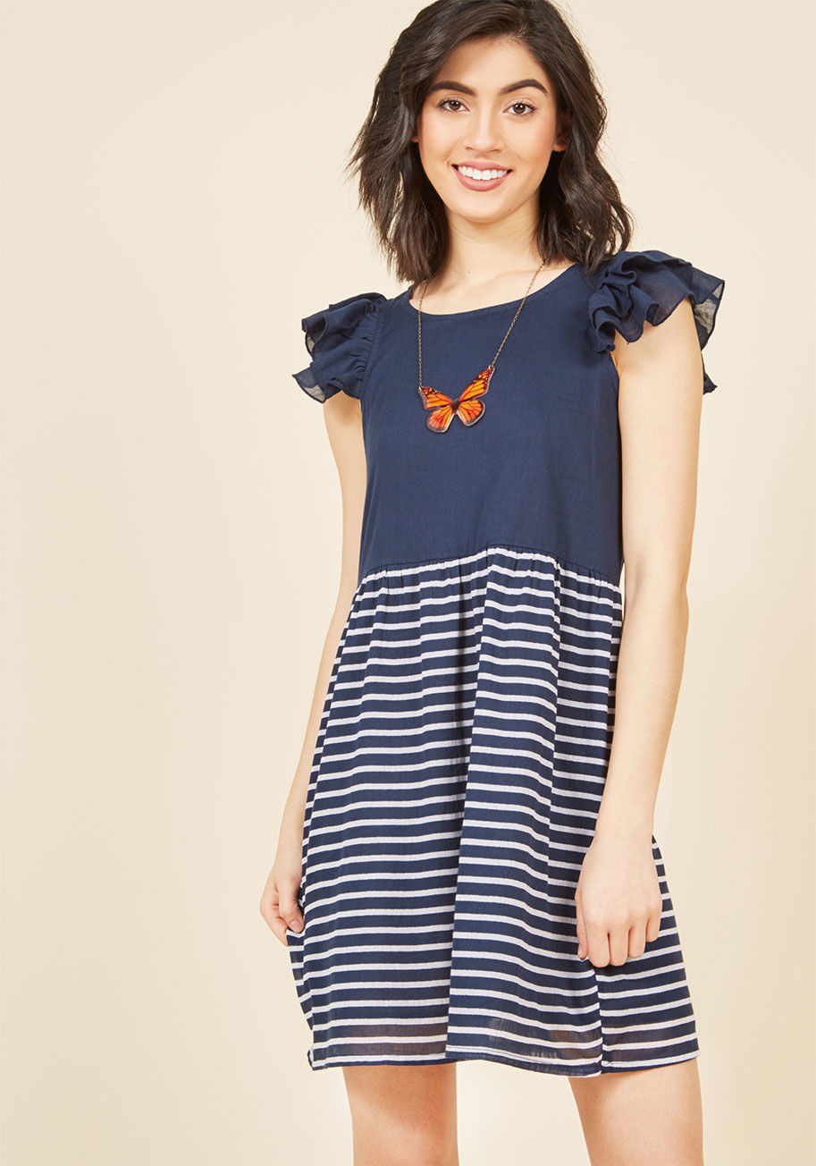  - While pondering how to accessorize this navy blue dress from Compania Fantastica, you decide that a salty breeze to highlight its ruffled cap sleeves and taupe stripes is the way to go! From its babydoll cut to its carefree vibe, this flirty cotton frock 