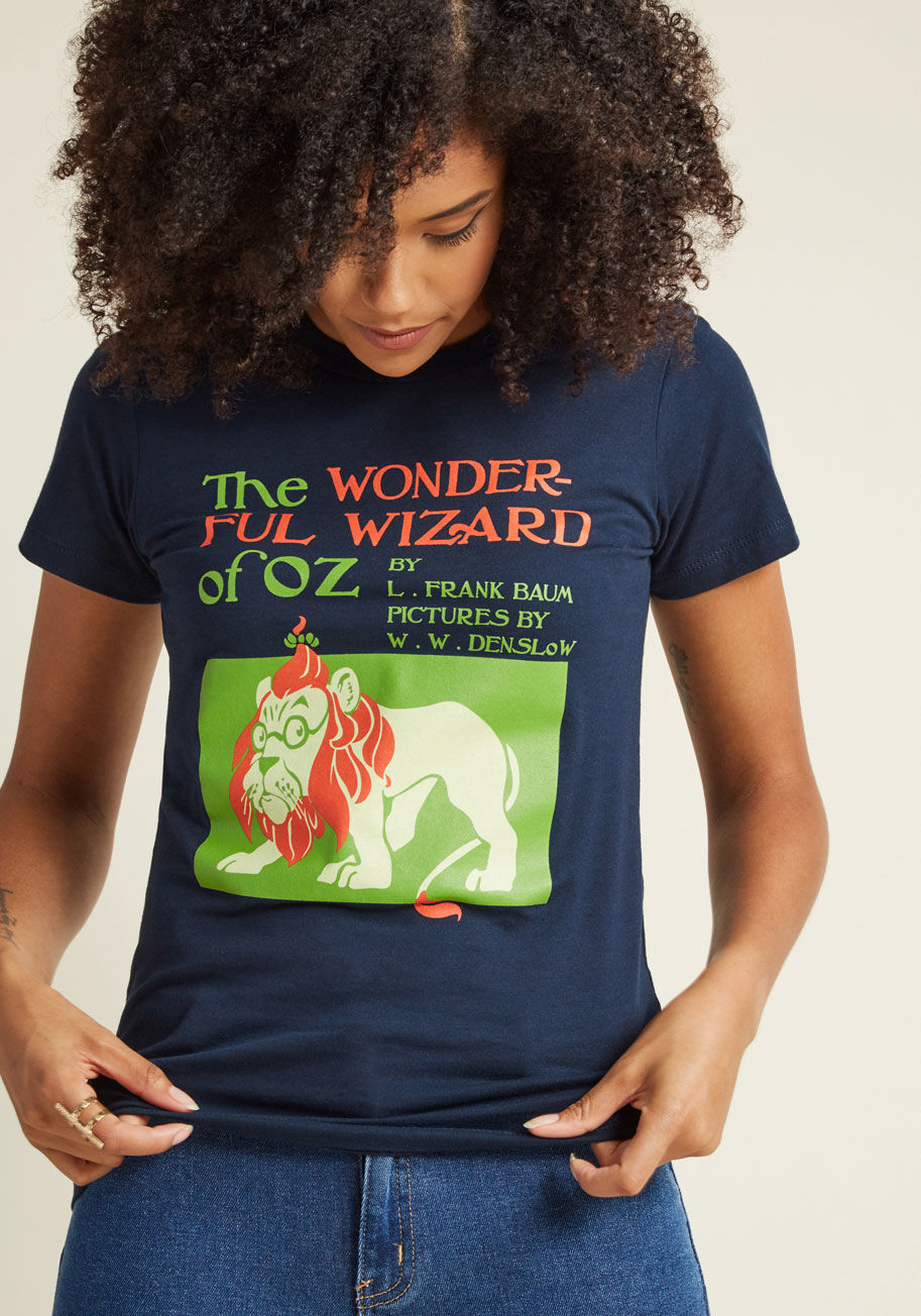  - Why click your heels to be transported to imaginative lands when you could just as easily flaunt this navy T-shirt? In green, coral, and ivory hues, this cotton tee is emblazoned with an iconic book cover - perfect for turning to anytime you need reminded