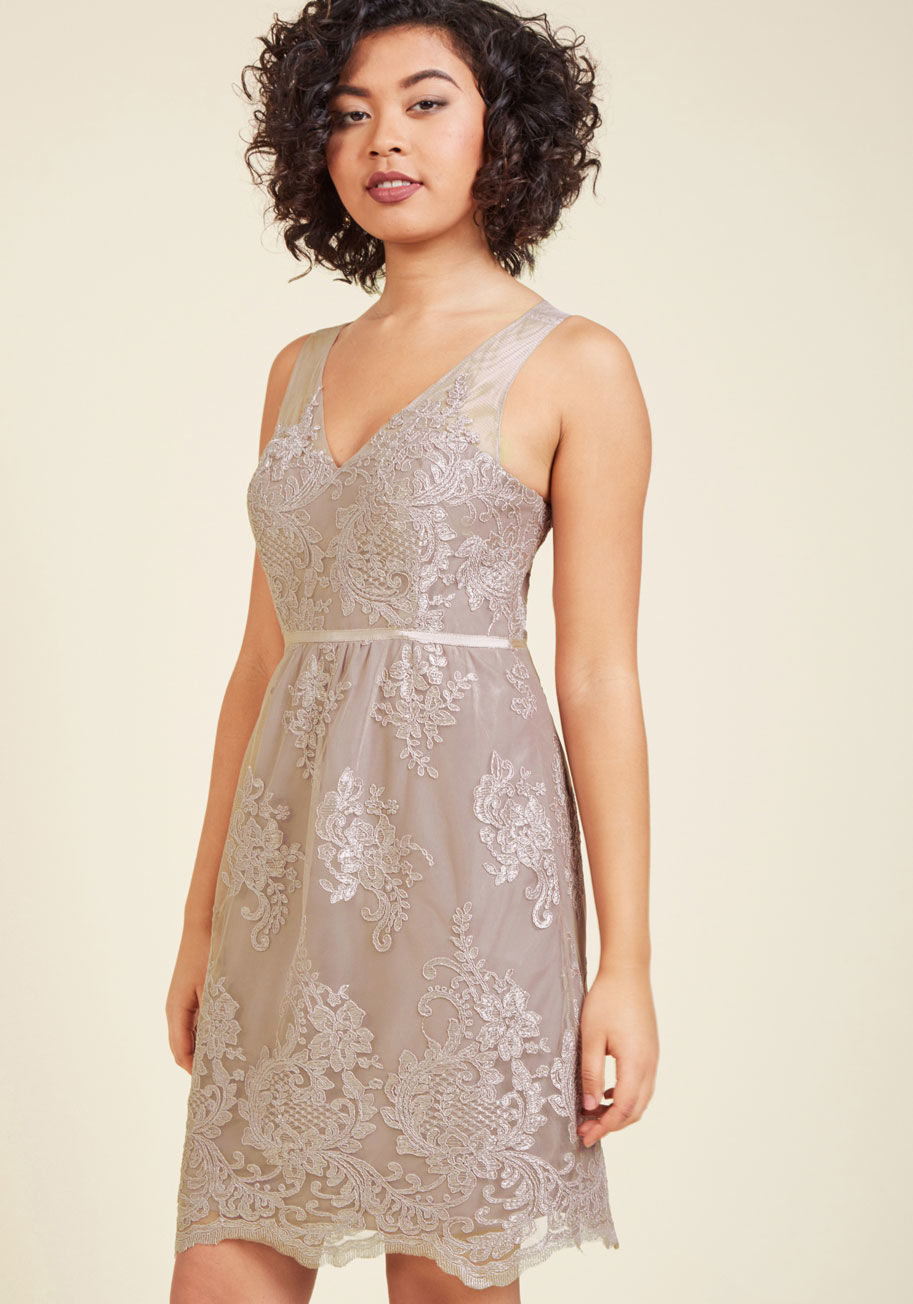  - You achieve the embodiment of elegance by donning this mauve cocktail dress! Adorned with a delicate floral lace pattern atop its sheer overlay, and an endlessly dainty row of covered buttons down the back, this formal frock from Jenny Yoo brings your sta
