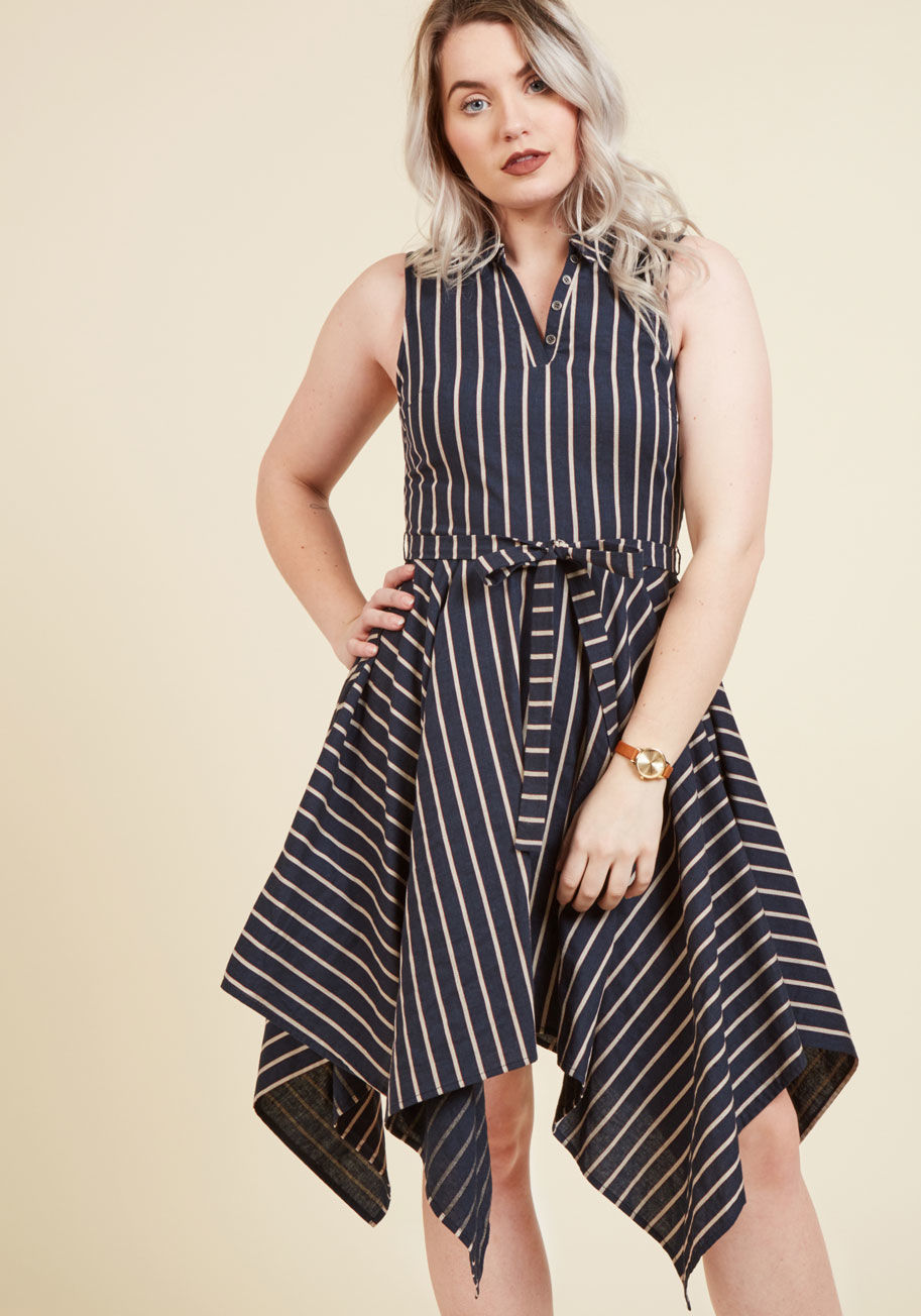  - You couldn't be less concerned with the occasion - what matters is that this navy blue shirt dress is seeing its debut! Confidently flaunting its beige and red stripes, silver-button-accented neckline, sash-topped waist, and handkerchief hem, you let this