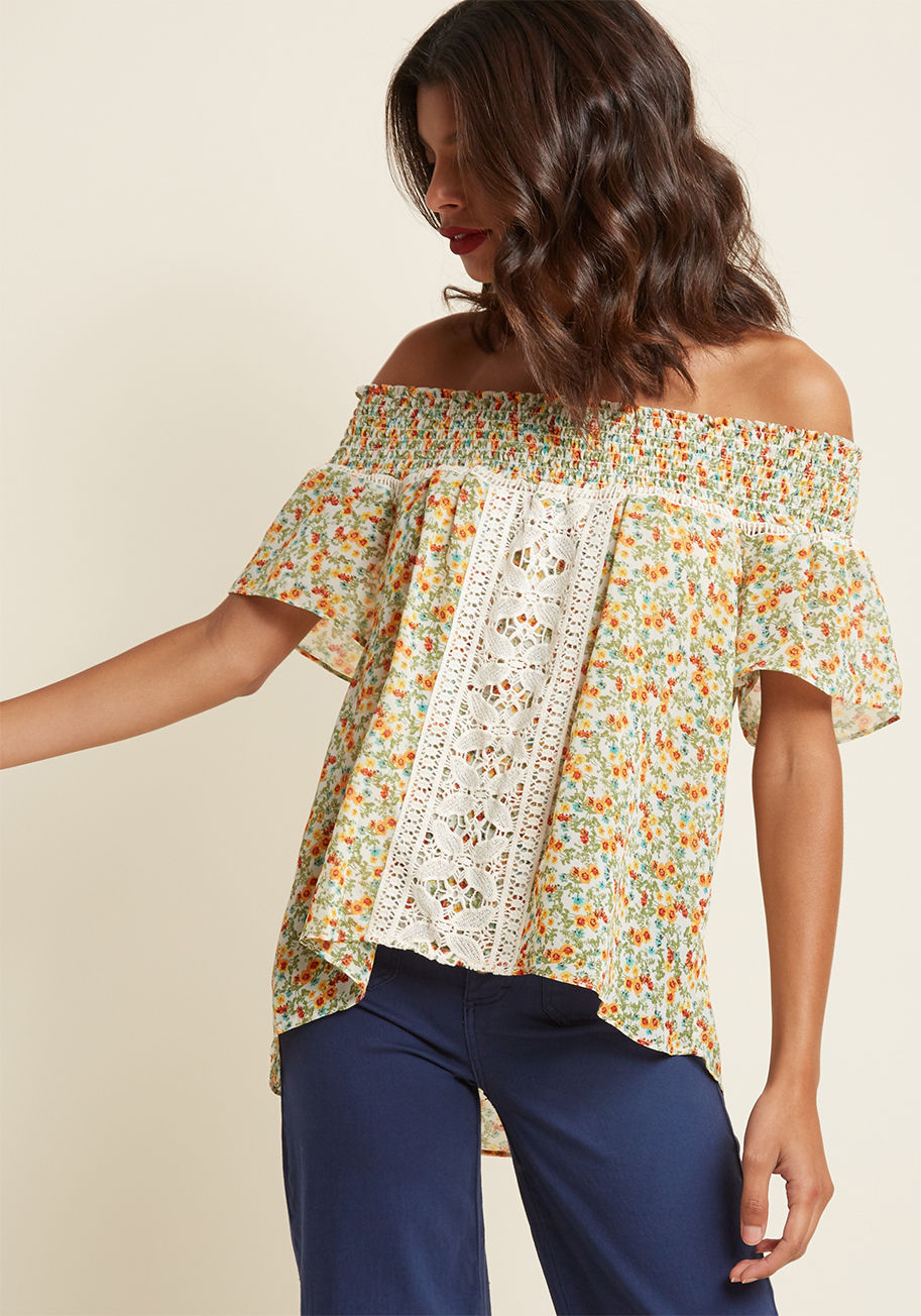  - Your confidence, charm, and cheerfulness will all bubble over when you're wearing this summery blouse! Flaunting an elasticized off-the-shoulder silhouette, cute crocheted paneling, and bright wildflowers all over its floaty ivory silhouette, this boho-in
