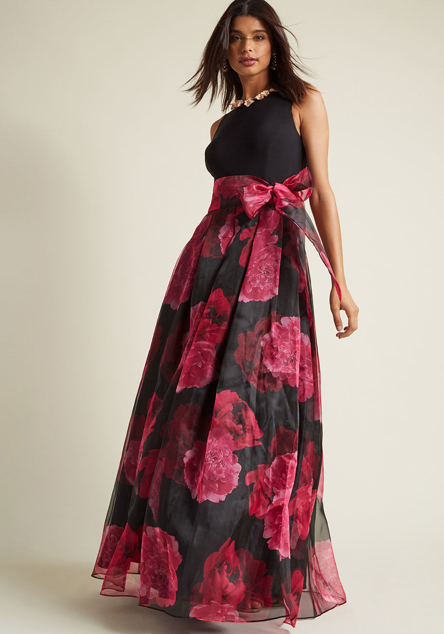  - You&rsquo;re well known for your glorious style at the gala, and this black dress makes no exception. As you waltz across the dance floor, the keyhole closure, dramatically pleated waist, removable chiffon sash, and magenta floral print of this cascading 