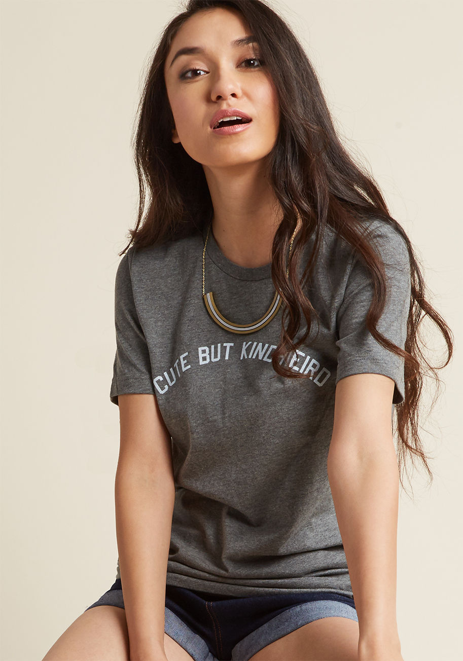 002 - There&rsquo;s something to be said for a style proclamation - and this grey tee says a lot! On those days when you want your outfit to do the talking, this scoop-neck knit will say it loud with its textured white letters, accurately capturing your unique 