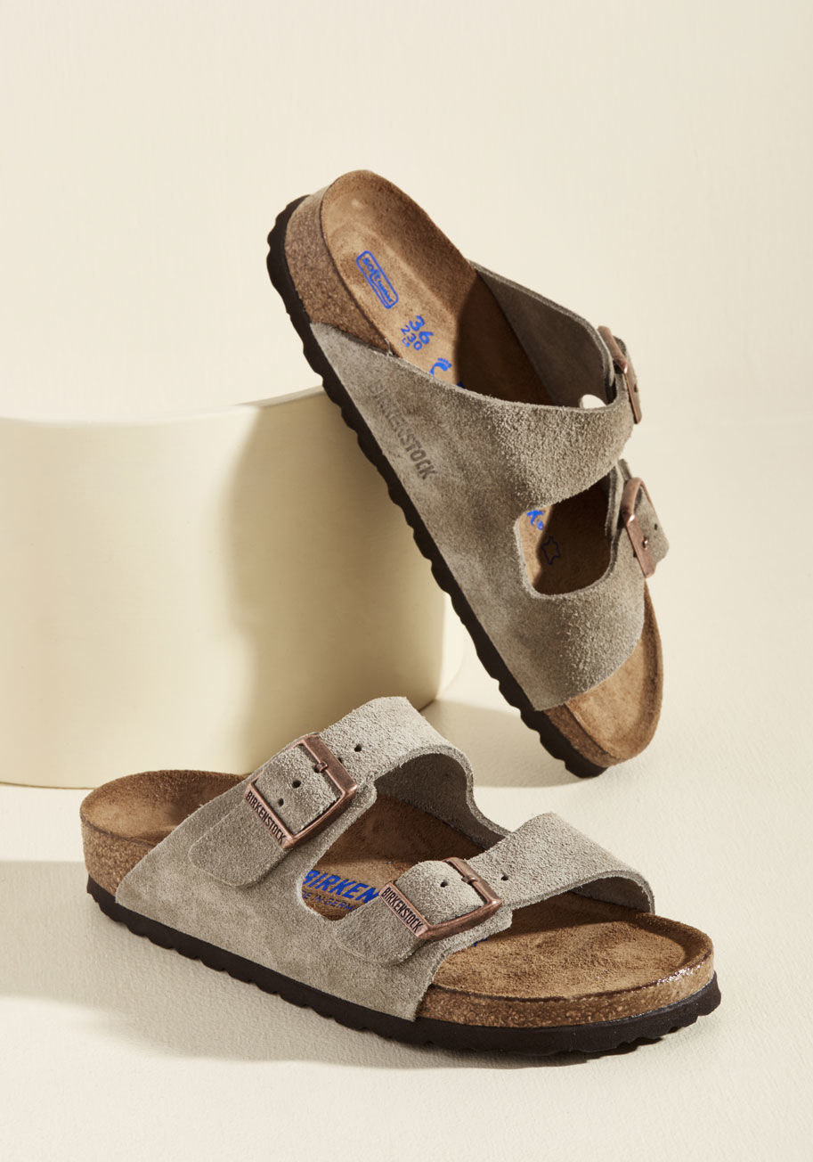 951303N - Set up your tent, kick off those hiking boots, and step into these Birkenstock Arizona sandals! In soft suede, this taupe-hued pair features a molded cork footbed with pronounced arch support, a deep heel cup, and a roomy toe box - keeping your feet cozy 