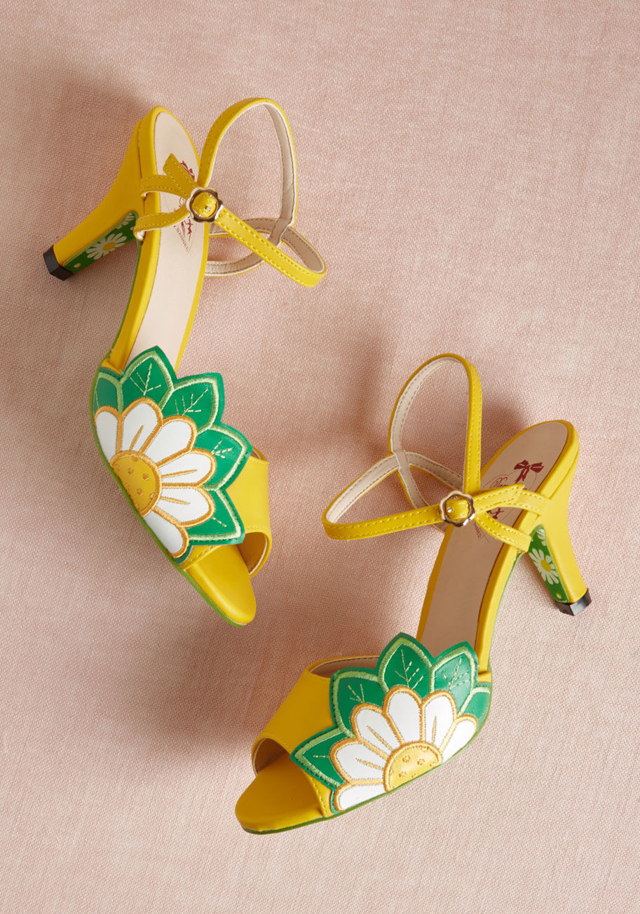 BND-263-yellow - These bright yellow heels from Banned really make your entrance known! As chipper as they are charming with their peep toes, sunflower appliques, mid-height heels, and daisy-patterned soles, these faux-leather lovelies are always a pleasure to have around