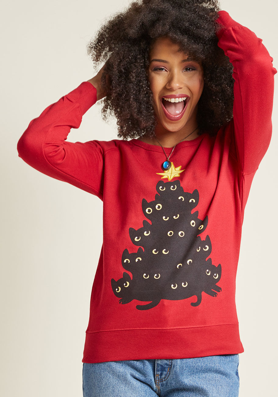There's a stack-up of festive felines on this red pullover, and they've got a sweet message for you - have a purr-worthy holiday! All snuggled together under a golden star, this merry bunch will have you pouncing on the spirit of this season. by Cat Tree Sweatshirt