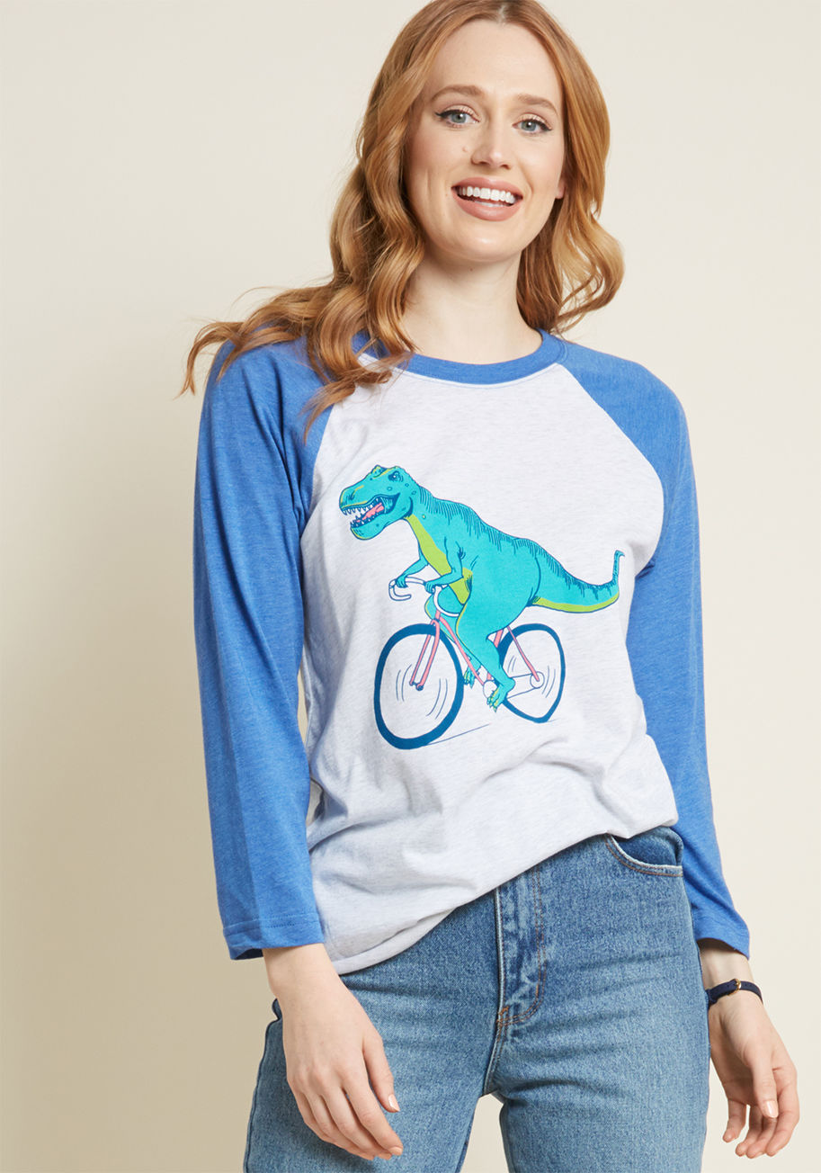 Dino Bike - Take your throwback sensibilities on the road by sporting this heather grey raglan tee! Rocking blue 3/4 sleeves and a teal-and-lime dino commuting on a bright pink bike, this ModCloth-exclusive top takes quirk and comfort, and combines them into one easy