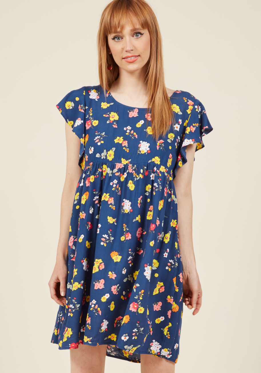 DR17LAUR-FLR-BLU - With positive energy as freely flowing as the flowers dancing down your navy blue shift dress, your embodiment of bliss is obvious to the eye! Brought to you by British cult brand Motel, this pink, yellow, and white patterned piece flaunts ruffled sleeves