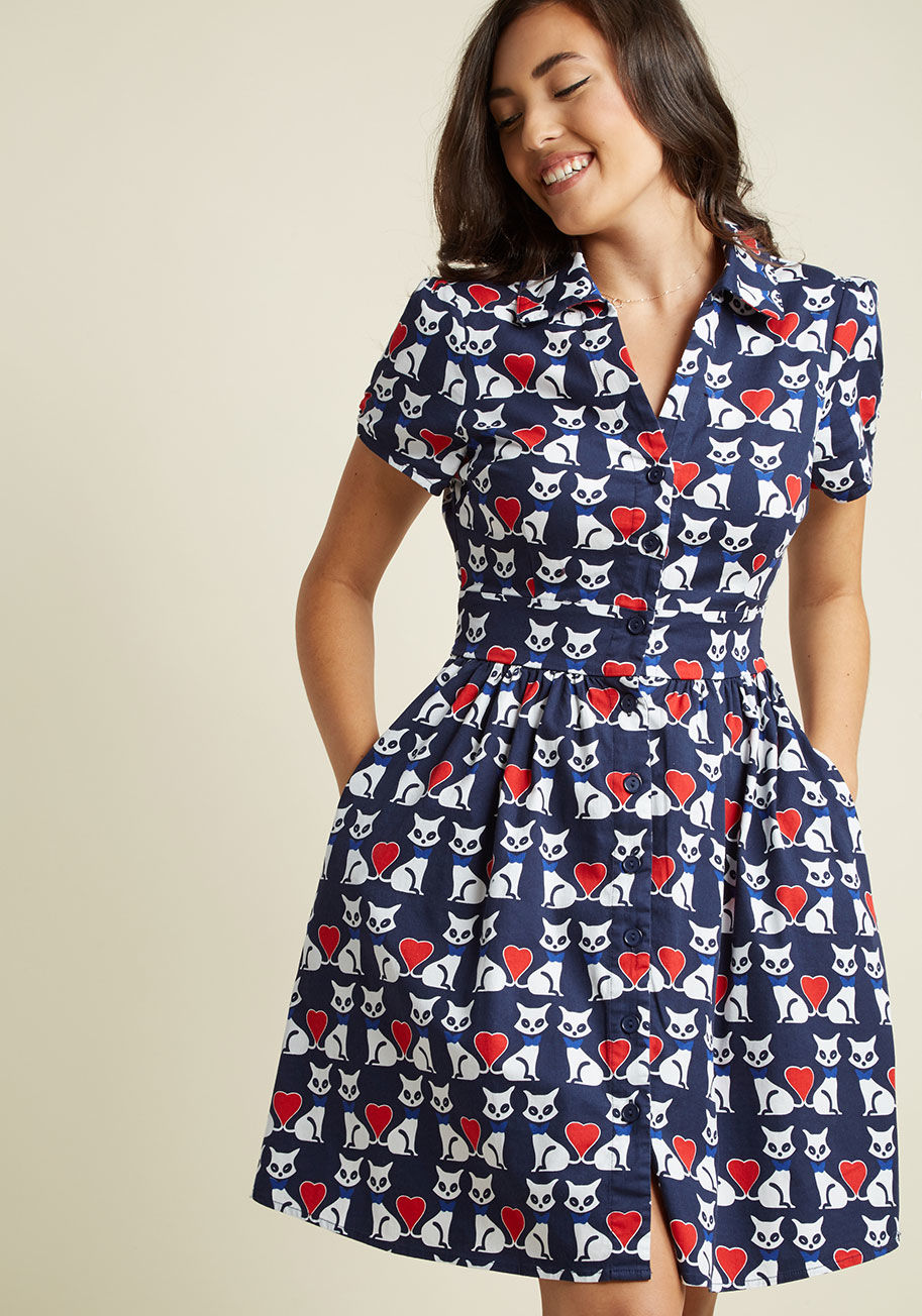 F3548E - Teach your students about signature style with this navy blue shirt dress - a ModCloth exclusive! Featuring ruched sleeves, a chic sash, and a light cotton blend printed with bowtie-clad white kitties - whose tails form bright red hearts - this pocketed A