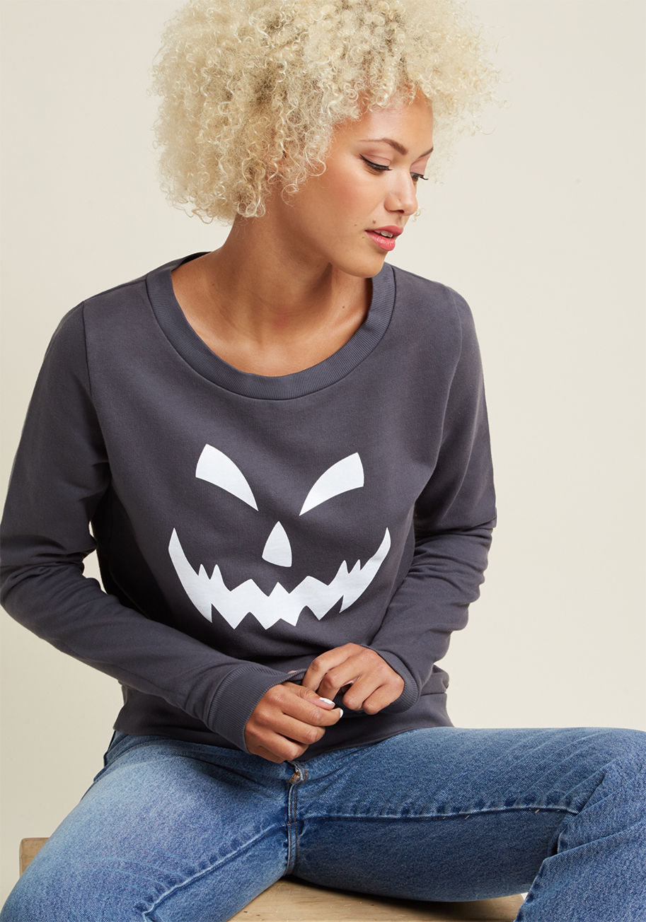 F8022D - Own up to your passion for All Hallows' fashion by rocking this grey sweatshirt - a ModCloth exclusive! The comfy, grey knit composing this casual separate features a white jack-o-lantern face that gives a frightful glow when caught