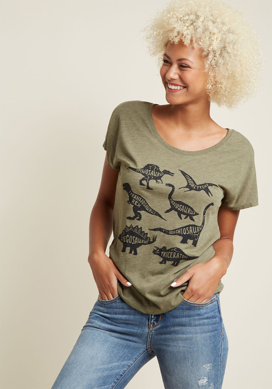 Know your Dino - Go on, flaunt your prehistoric prowess by rockin' this olive green T-shirt! A ModCloth exclusive, this loose-fit tee is emblazoned with a graphic of correctly-identified dinosaurs - a look that's sure to prompt conversation from academic chats to passiona