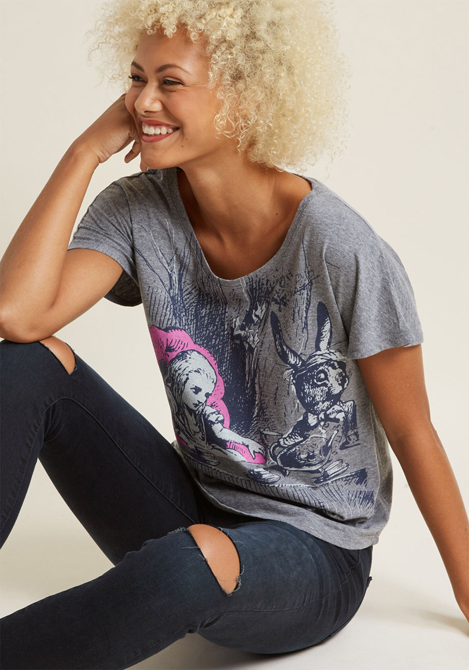L-1224 - Whether you're sporting this grey graphic T-shirt to cozy up with a book or for a casual stroll around the block, you feel perfectly at peace with your love of lit on display. By Out of Print, this loose-fit tee is emblazoned with a navy Alice