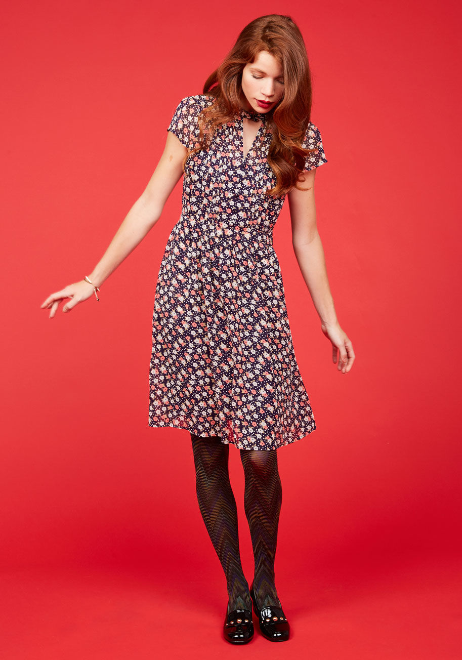 MCD1076B - By the light of dawn, you don this floral dress and depart for your artistic internship. As you drift amid the galleries, the buttoned neckline, pintucked bodice, and pink-and-ivory print of this navy-based ensemble - part of our ModCloth namesake label -