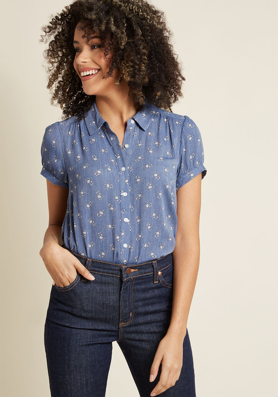 MCT1589 - Feeling free-spirited on a day with scarce to-dos is why this chambray blouse exists! The cute collar, gathered shoulders, sweet short sleeves, and muted white wildflowers of this lightweight top from our ModCloth namesake label culminate