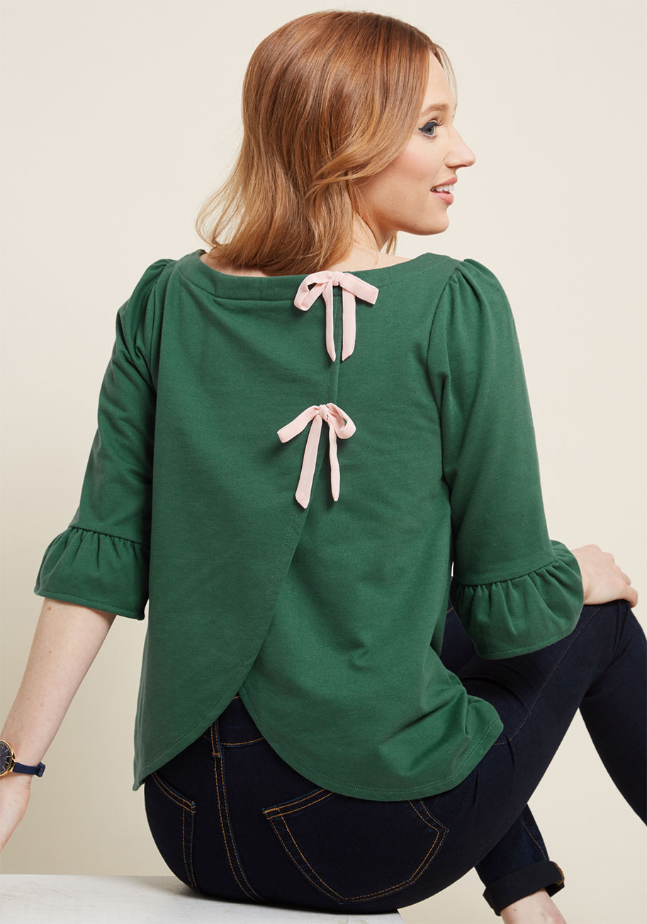 MCT1604 - Even the smallest errand on a weekend can be made stylish with this muted green pullover! With ruffled 3/4-length sleeves, a wide neckline, and a pair of soft pink ties detailing its tulip-style back, this French terry piece from our ModCloth namesake lab