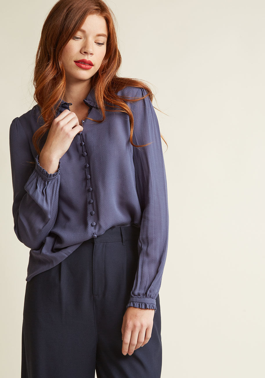 MCT9000 - A feminine nod to the fashionable past, this delicate blue blouse makes for a blissful wearing experience! Sweetened up with a ruffled, rounded collar and coordinating sleeve cuffs, a decoratively fastened bodice with functional top-five buttons, and a li