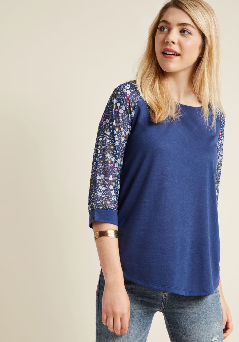MDT1156 - You're more prepared than ever to 'field' questions about this floral top! Its slub knit bodice boasts a rich blue hue that's pleasing to the eye, while its sheer chiffon sleeves showcase a garden of grey, olive, sky, pink, and white wildflowers. Peeps wi
