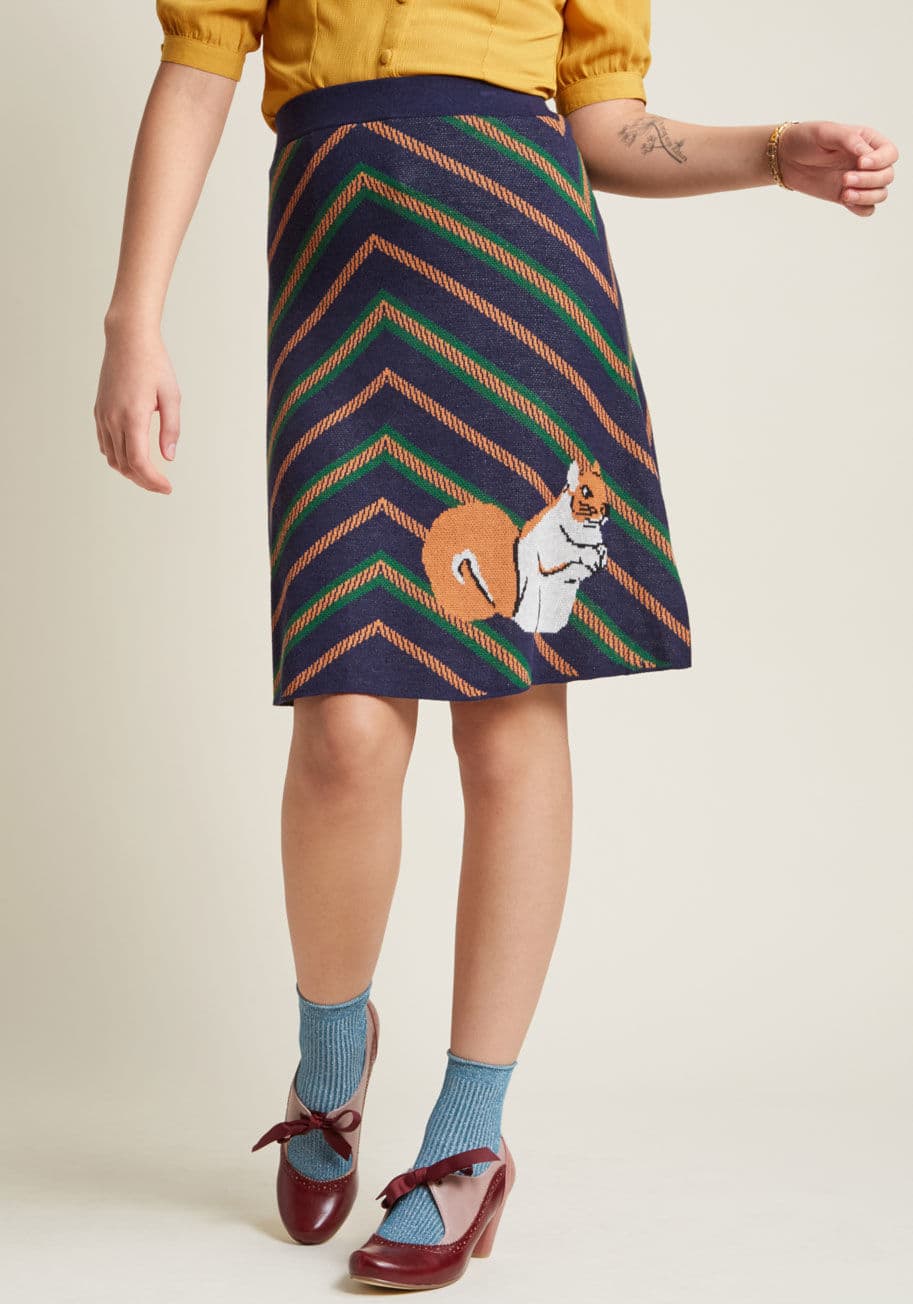 SK08 - Be the queen of cozy and the empress of chic by sporting this sweet sweater skirt! With a ModCloth-exclusive design of green-and-orange chevron stripes and an intarsia squirrel, this super-soft, navy A-line adds a touch of modern femininity to her ladyshi